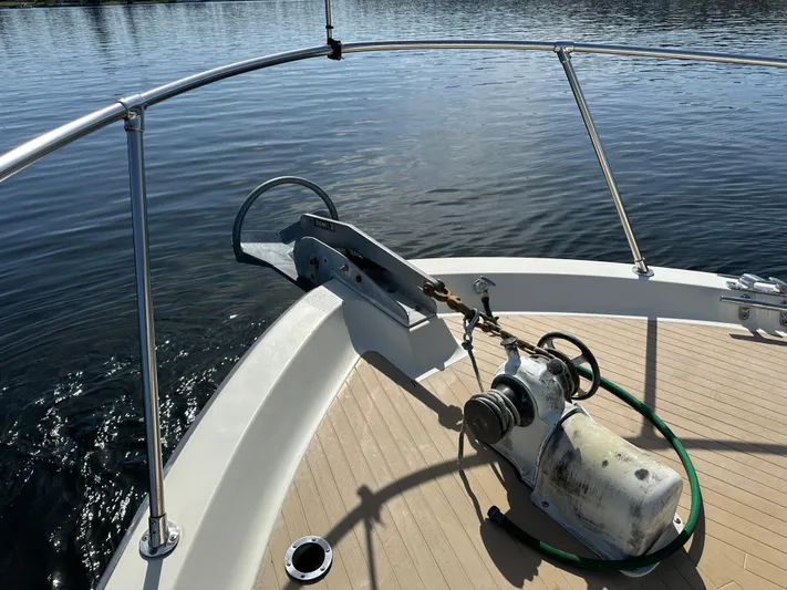  Yacht Photos Pics 1982 Tollycraft Tri Cabin boat deck with anchor and winch system on calm water.
