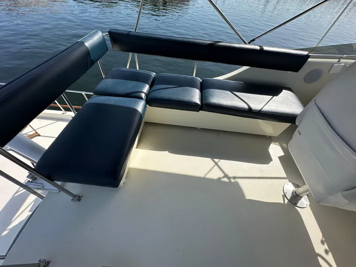  Yacht Photos Pics 1982 Tollycraft Tri Cabin boat seating area with blue cushions, overlooking water.