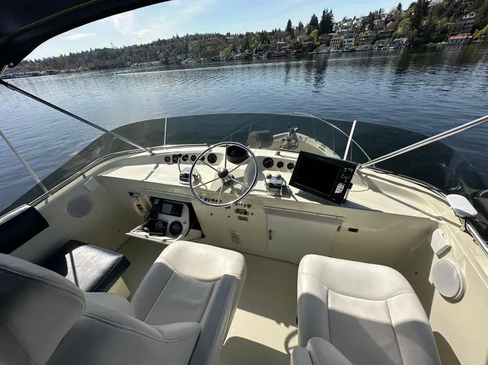  Yacht Photos Pics 1982 Tollycraft Tri Cabin helm with steering wheel, controls, and lake view.