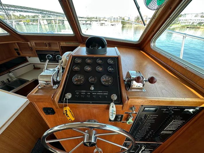  Yacht Photos Pics 1982 Tollycraft Tri Cabin helm with gauges, steering wheel, and waterfront view.