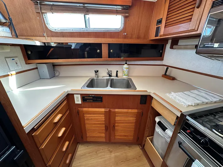  Yacht Photos Pics 1982 Tollycraft Tri Cabin kitchen with wooden cabinets, dual sink, and stove.