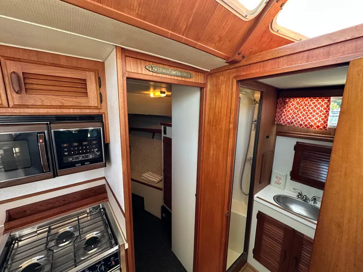  Yacht Photos Pics 1982 Tollycraft Tri Cabin interior with kitchen, bathroom, and wood paneling.