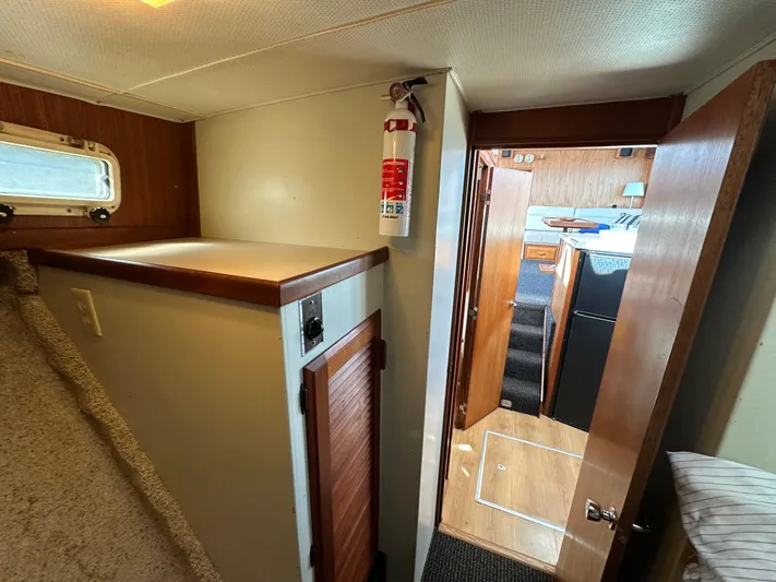  Yacht Photos Pics 1982 Tollycraft Tri Cabin interior with wood accents and fire extinguisher.