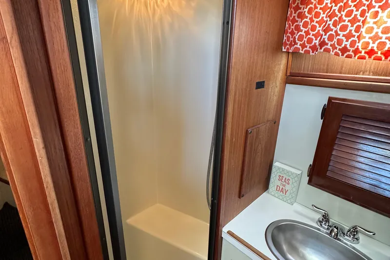  Yacht Photos Pics 1982 Tollycraft Tri Cabin bathroom with shower, sink, and nautical decor.