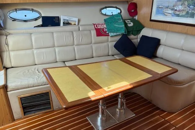  Yacht Photos Pics Interior of 2000 Tiara Yachts 4100 Open with cushioned seating and wooden table.