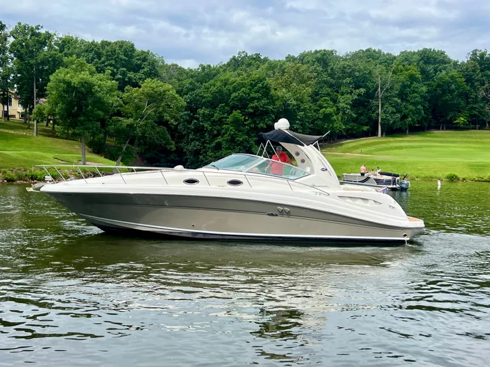  Yacht Photos Pics 2006 Sea Ray 340 Sundancer cruising on a scenic lake with lush green trees.