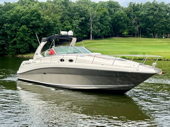  Yacht Photos Pics 2006 Sea Ray 340 Sundancer cruising on a serene lake with lush green trees.