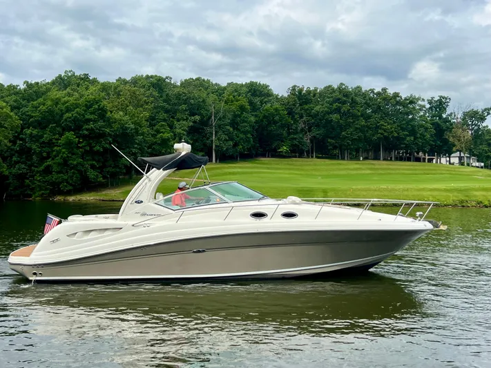  Yacht Photos Pics 2006 Sea Ray 340 Sundancer yacht cruising on a serene lake with lush green surroundings.