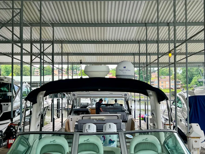  Yacht Photos Pics 2006 Sea Ray 340 Sundancer docked under covered marina, featuring spacious seating and modern amenities.