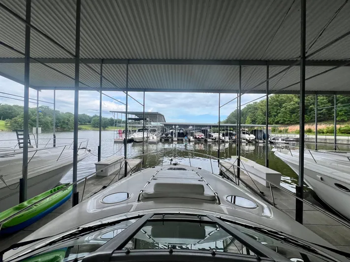  Yacht Photos Pics 2006 Sea Ray 340 Sundancer docked in a marina with surrounding boats and lush greenery.