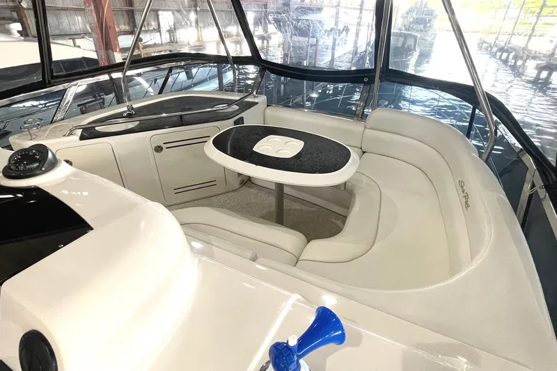  Yacht Photos Pics 2009 Sea Ray Sedan Bridge interior with curved seating and table, docked in a marina.