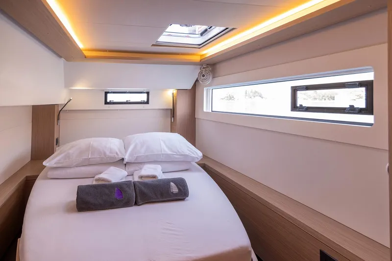  Yacht Photos Pics Luxurious cabin interior of 2024 Lagoon 450 F catamaran with modern design and cozy bedding.