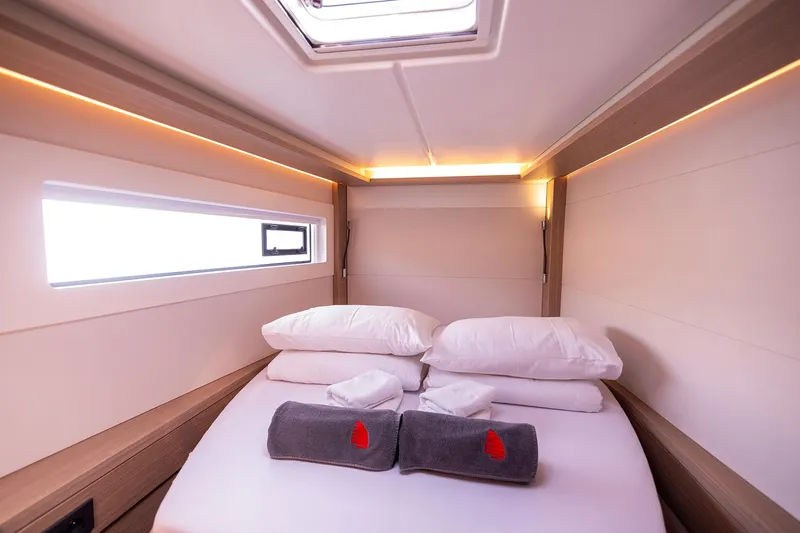  Yacht Photos Pics Luxurious cabin interior of 2024 Lagoon 450 F yacht with cozy bedding and ambient lighting.