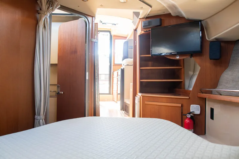  Yacht Photos Pics Interior of 2016 Ranger Tugs R-29 boat with bed, TV, and wooden cabinetry.