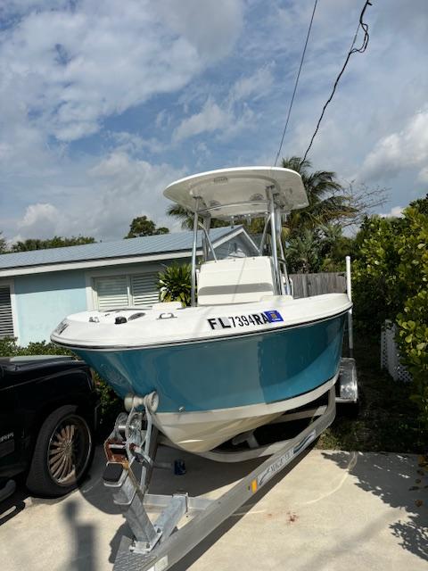 2016 Release 208 RX boat on trailer, parked in driveway, under cloudy sky.