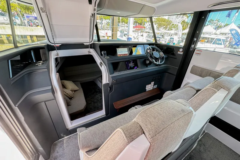  Yacht Photos Pics 2024 Axopar 45 XC Cross Cabin interior with modern helm, seating, and cabin access.