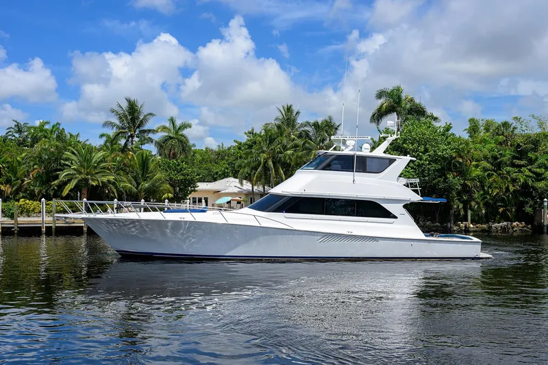 Fine Expierence Yacht Photos Pics 2001 Viking 65 Enclosed Bridge yacht on calm water, surrounded by lush greenery.
