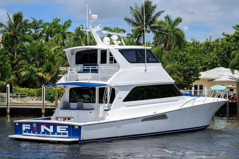 Fine Expierence Yacht Photos Pics 2001 Viking 65 Enclosed Bridge yacht docked near tropical foliage.