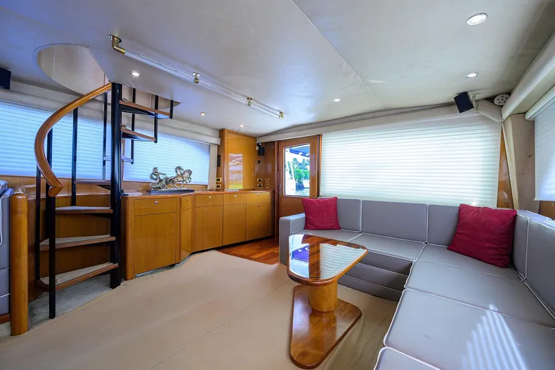 Fine Expierence Yacht Photos Pics Luxurious interior of 2001 Viking 65 Enclosed Bridge yacht with modern seating and spiral staircase.