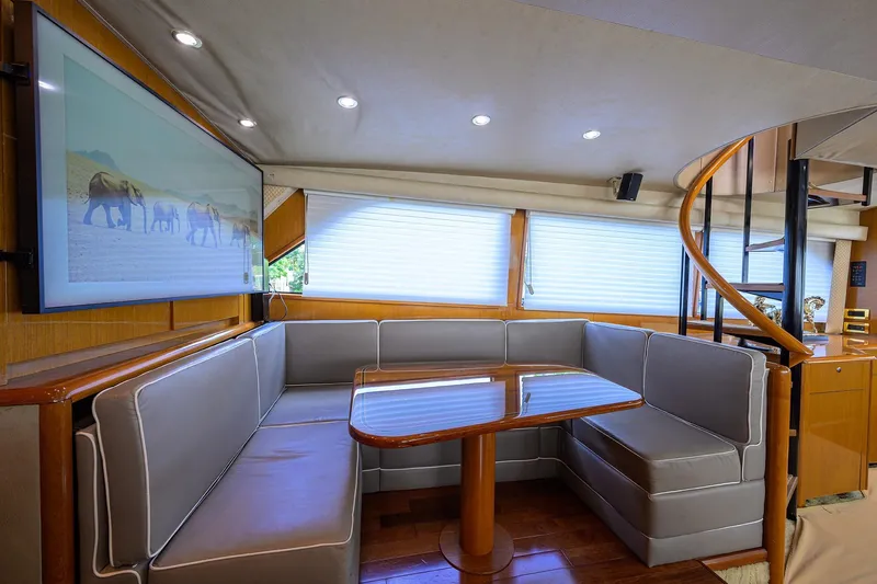 Fine Expierence Yacht Photos Pics Luxurious interior of 2001 Viking 65 Enclosed Bridge yacht with elegant seating and spiral staircase.