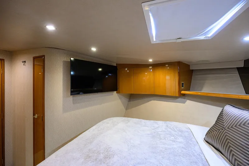Fine Expierence Yacht Photos Pics Interior of 2001 Viking 65 Enclosed Bridge yacht bedroom with TV and skylight.