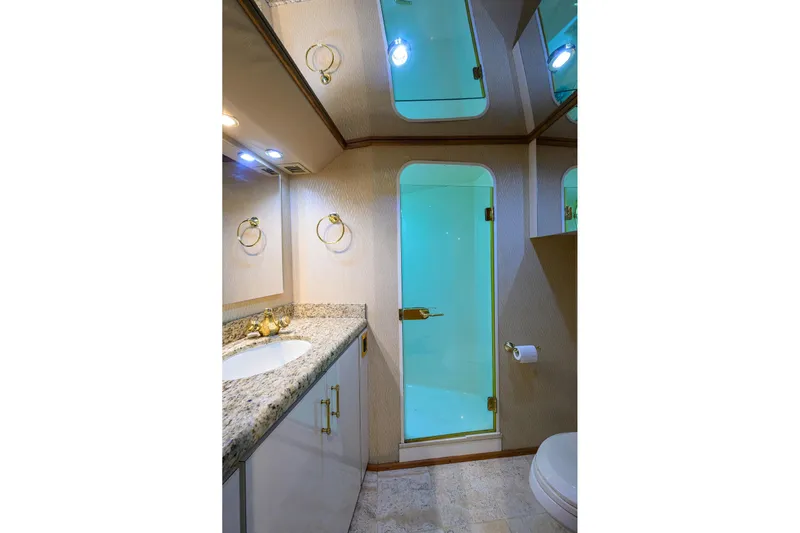Fine Expierence Yacht Photos Pics Luxurious bathroom in 2001 Viking 65 Enclosed Bridge yacht with granite countertop and glass shower.
