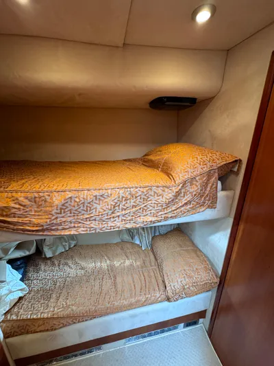  Yacht Photos Pics Bunk beds in 2008 Sunseeker Manhattan 70 yacht cabin, featuring cozy bedding and warm lighting.