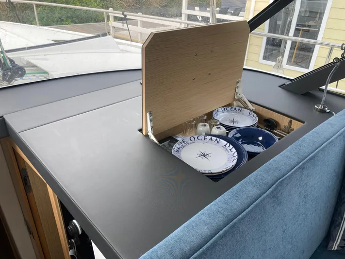  Yacht Photos Pics Interior of 2022 Moody Decksaloon 41 with hidden storage for nautical-themed plates.