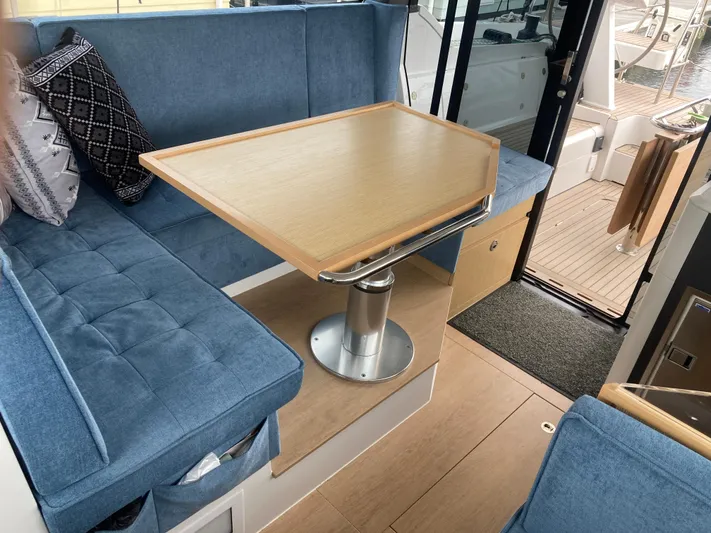  Yacht Photos Pics Cozy interior of 2022 Moody Decksaloon 41 with blue seating and wooden table.