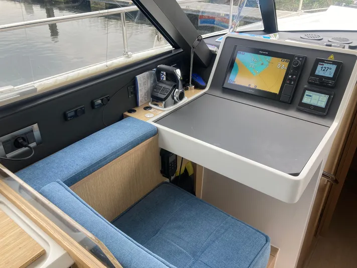  Yacht Photos Pics Modern navigation station on 2022 Moody Decksaloon 41 yacht with blue seating and electronic displays.