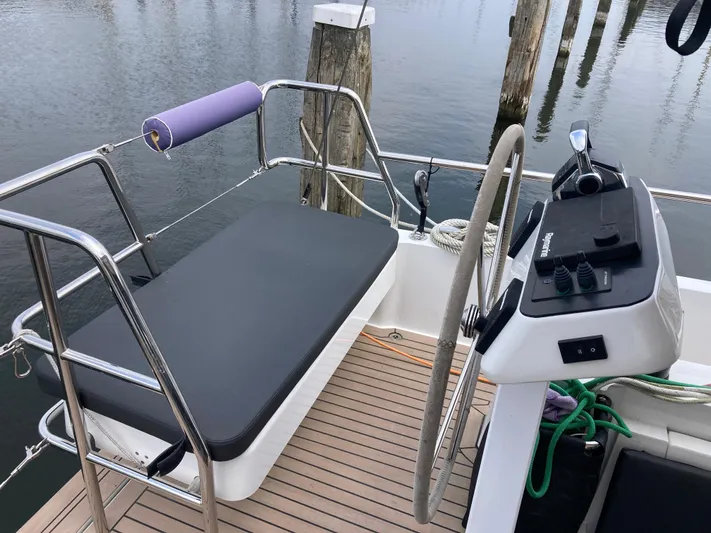  Yacht Photos Pics Moody Decksaloon 41 (2022) cockpit with steering wheel and seating, docked by wooden posts.