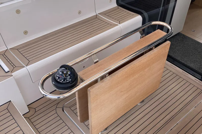  Yacht Photos Pics 2022 Moody Decksaloon 41 yacht interior with wooden table and compass.