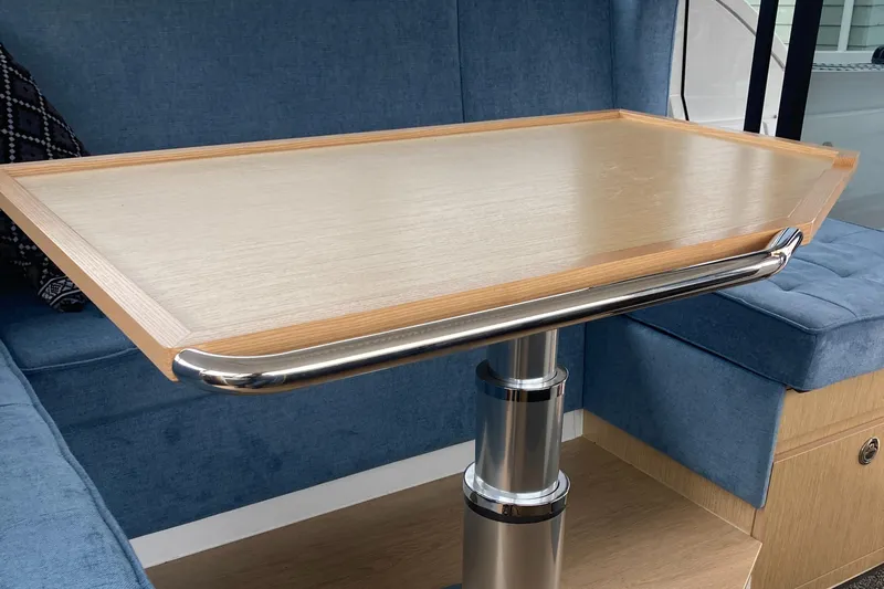  Yacht Photos Pics Interior of 2022 Moody Decksaloon 41 with wooden table and blue seating.