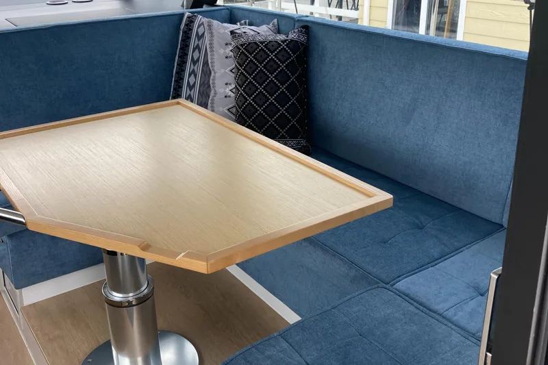  Yacht Photos Pics Interior of 2022 Moody Decksaloon 41 with blue seating and wooden table.