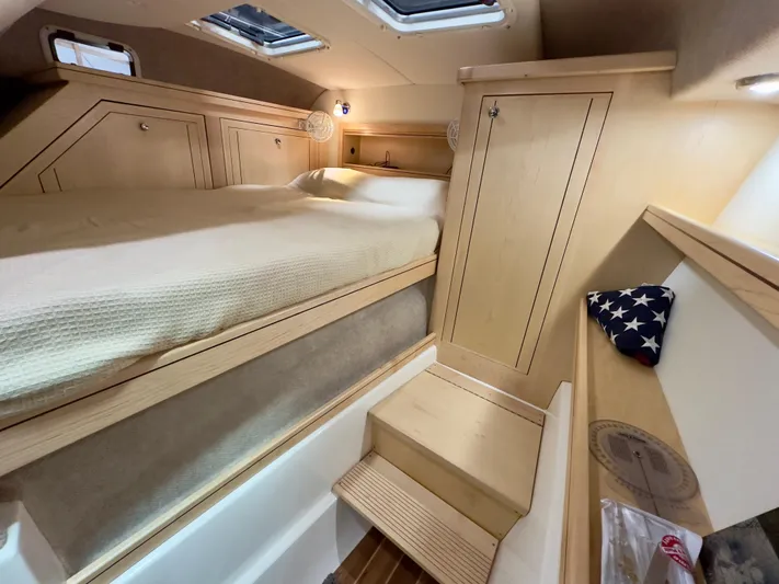  Yacht Photos Pics Cozy cabin interior of 2026 Aspen C108 with bed, wooden steps, and storage.