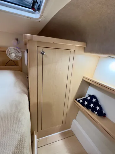  Yacht Photos Pics Compact interior of 2026 Aspen C108 with wooden cabinetry and star-patterned cushion.