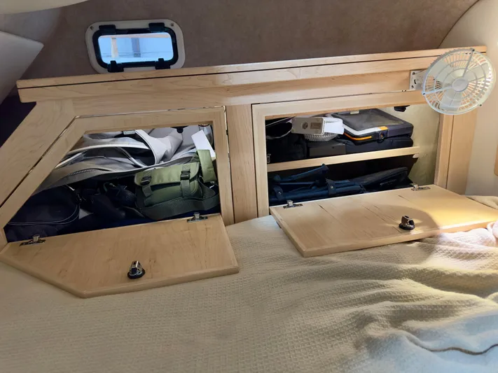  Yacht Photos Pics Camper interior storage with open wooden cabinets, showcasing organized gear and luggage. Aspen C108, 2026 model.