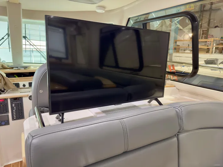  Yacht Photos Pics Flat-screen TV in 2026 Aspen C108 boat interior, featuring modern seating and large windows.