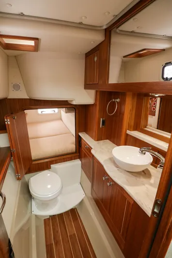  Yacht Photos Pics Luxurious Aspen C108 2026 yacht bathroom with wood accents, modern sink, and cozy cabin space.
