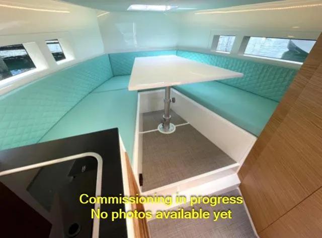  Yacht Photos Pics 2024 De Antonio Yachts D28 Cruiser interior with turquoise seating and table.