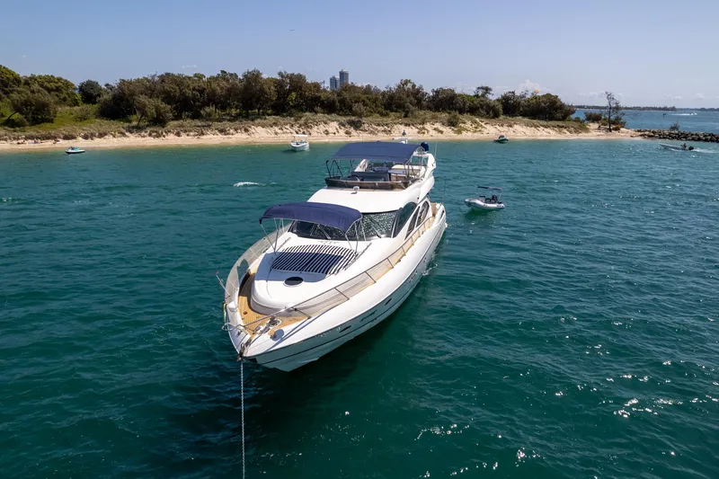 Shhmic Yacht Photos Pics Luxury Sunseeker Manhattan 74 yacht anchored near a scenic beach, 2001 model.