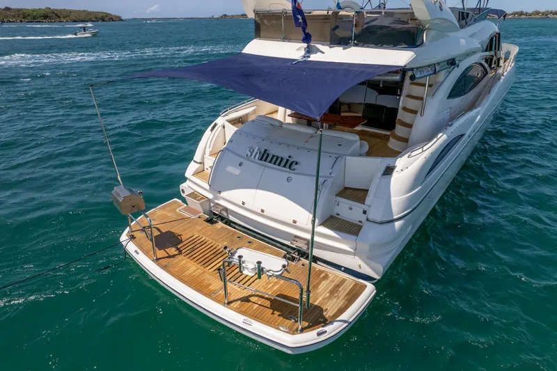 Shhmic Yacht Photos Pics 2001 Sunseeker Manhattan 74 yacht on blue ocean, rear view with sunshade.