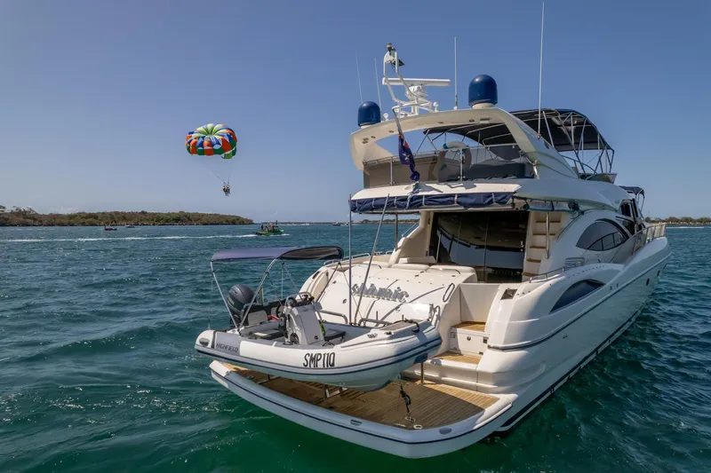Shhmic Yacht Photos Pics Luxury Sunseeker Manhattan 74 yacht, 2001 model, with parasailing in the background.