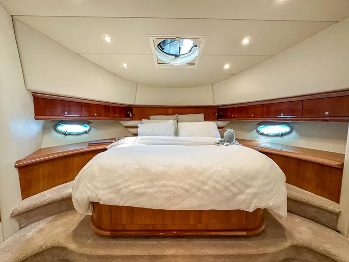 Shhmic Yacht Photos Pics Luxurious bedroom interior of 2001 Sunseeker Manhattan 74 yacht with elegant wood finish.