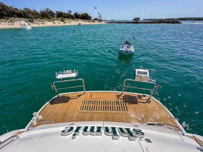 Shhmic Yacht Photos Pics Sunseeker Manhattan 74 yacht on clear blue water near a sandy beach, 2001 model.
