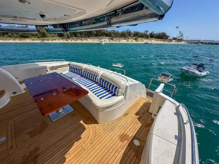 Shhmic Yacht Photos Pics Luxurious Sunseeker Manhattan 74 yacht deck with seating, table, and ocean view.