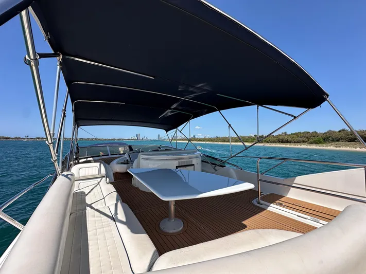Shhmic Yacht Photos Pics Luxurious 2001 Sunseeker Manhattan 74 yacht deck with seating and table, under a canopy.