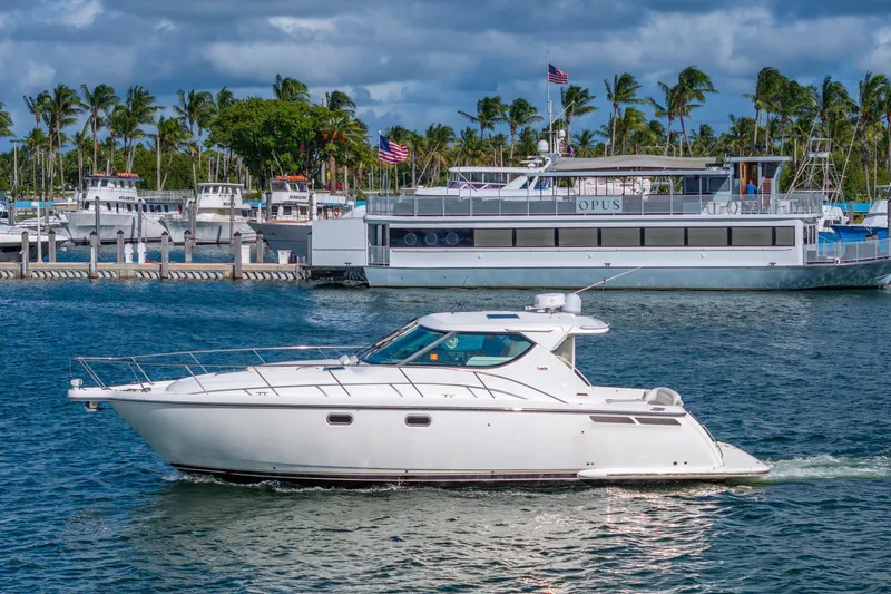  Yacht Photos Pics 2007 Tiara Yachts 4300 Sovran cruising in a marina with palm trees and boats.