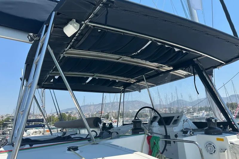  Yacht Photos Pics Cockpit view of 2012 Lagoon 450 catamaran with canopy and steering wheel in marina.