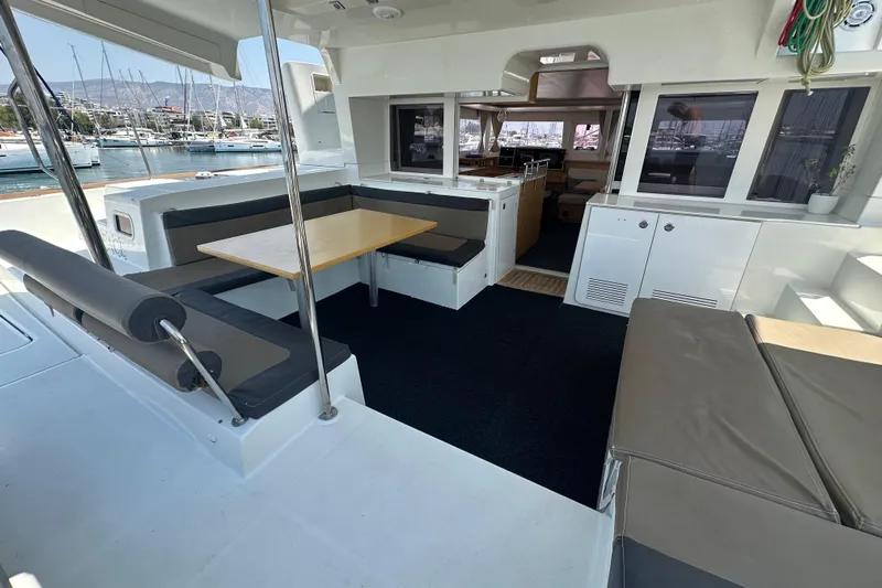  Yacht Photos Pics Spacious 2012 Lagoon 450 catamaran interior with seating and dining area in marina setting.